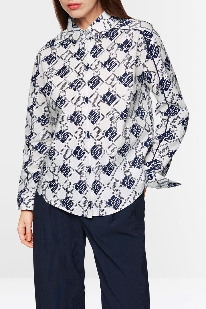 Chemise à imprimé chaînes graphiques, coupe droite, confortable, portée avec pantalon marine pour un look moderne.