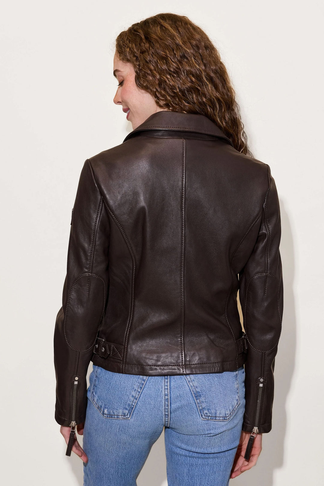 Vue arrière du Manteau Pasja en cuir véritable, style perfecto avec détails zippés, porté avec un jean pour un look casual-chic.