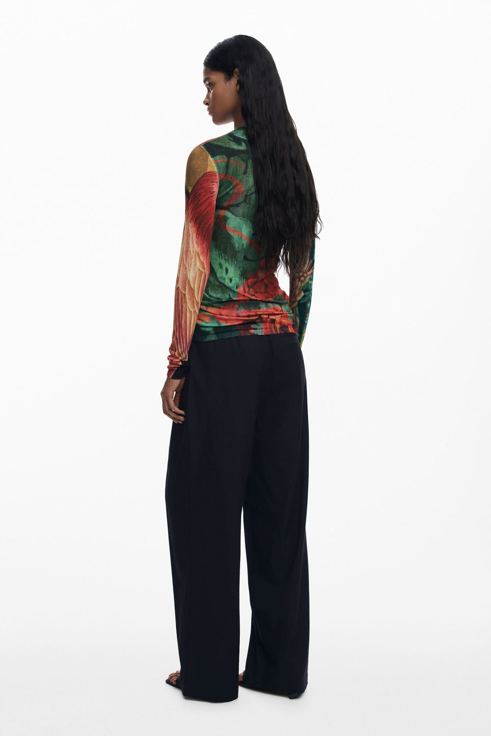 Chandail ajusté à col montant avec imprimé floral vibrant, porté avec un pantalon large, vue de dos.