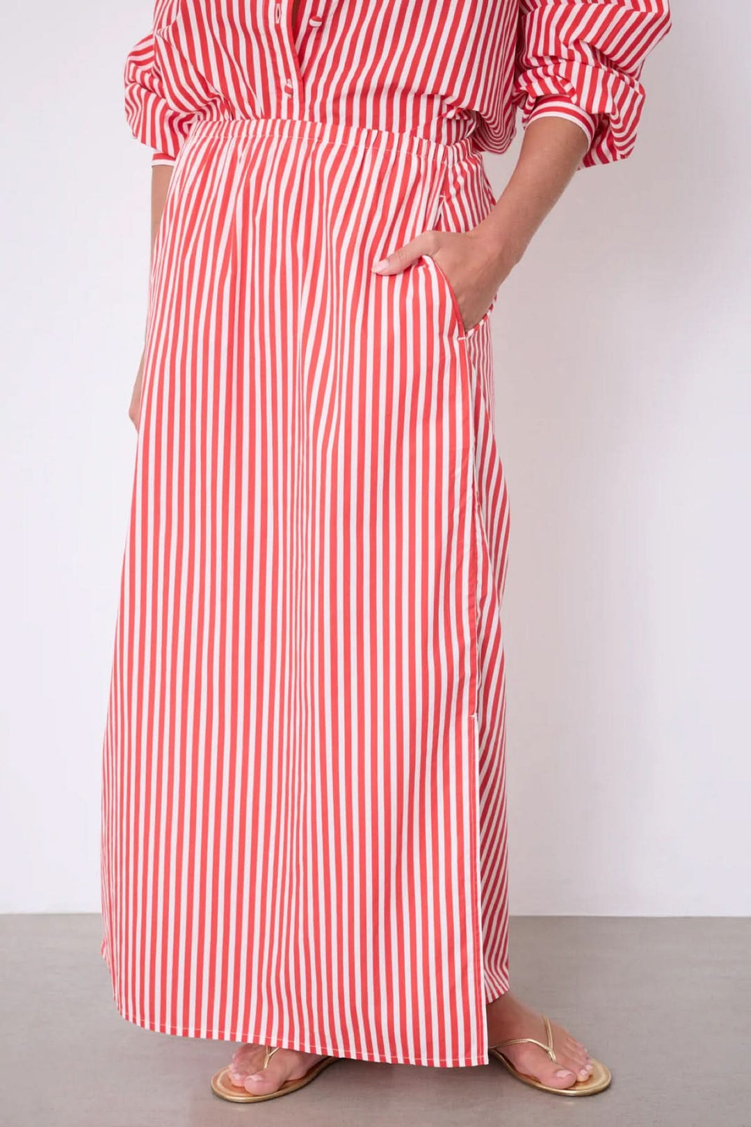 Jupe Ilona longue rayée taille élastique avec poches latérales et fente, idéal pour un look estival élégant et confortable.