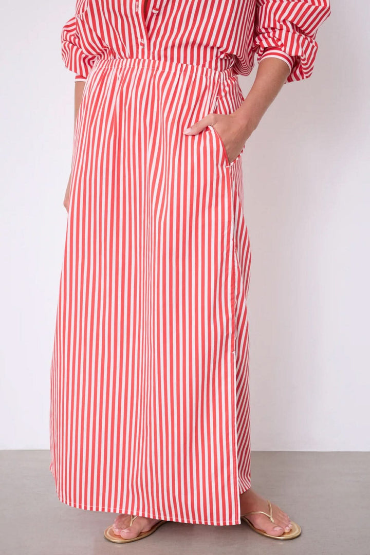 Jupe Ilona longue rayée taille élastique avec poches latérales et fente, idéal pour un look estival élégant et confortable.