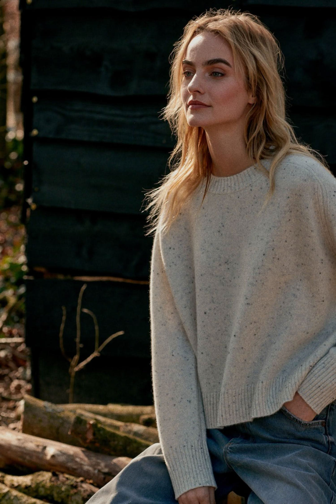 Femme portant un chandail moucheté en cachemire avec un look décontracté en pleine nature.