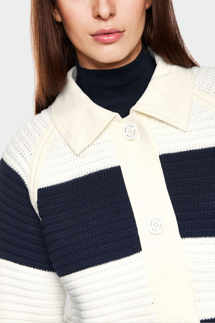 Cardigan court à blocs de couleur avec empiècements en denim, offrant un look décontracté et moderne.