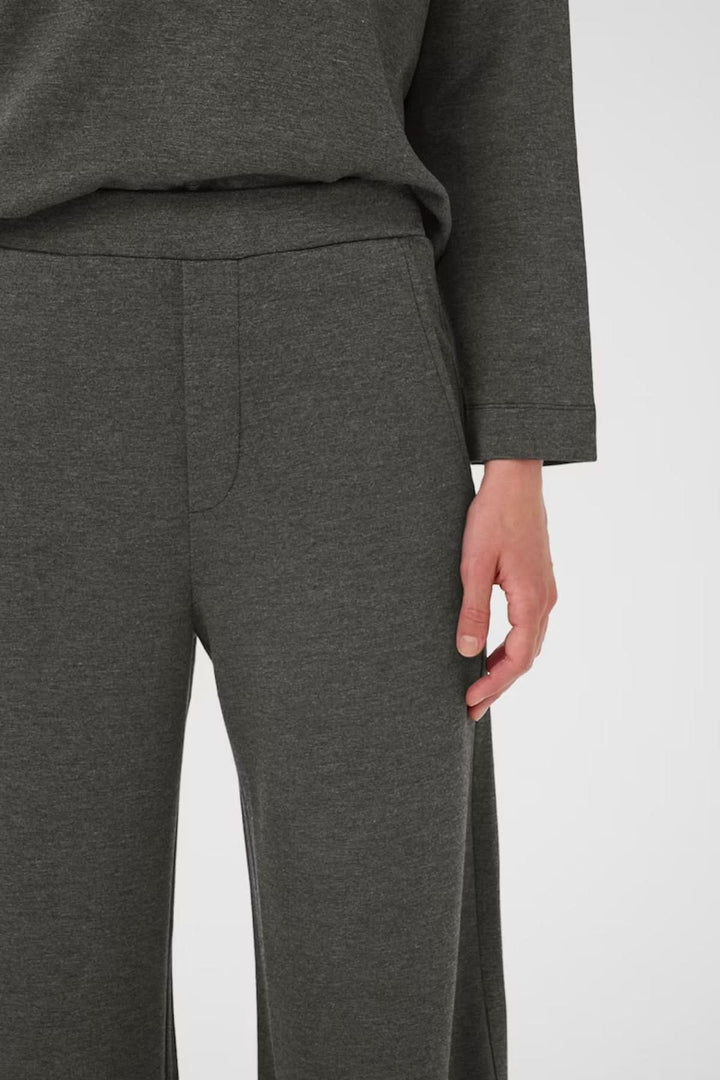 Pantalon large à taille haute en maille fluide, vue de près, montrant confort et élégance décontractée.