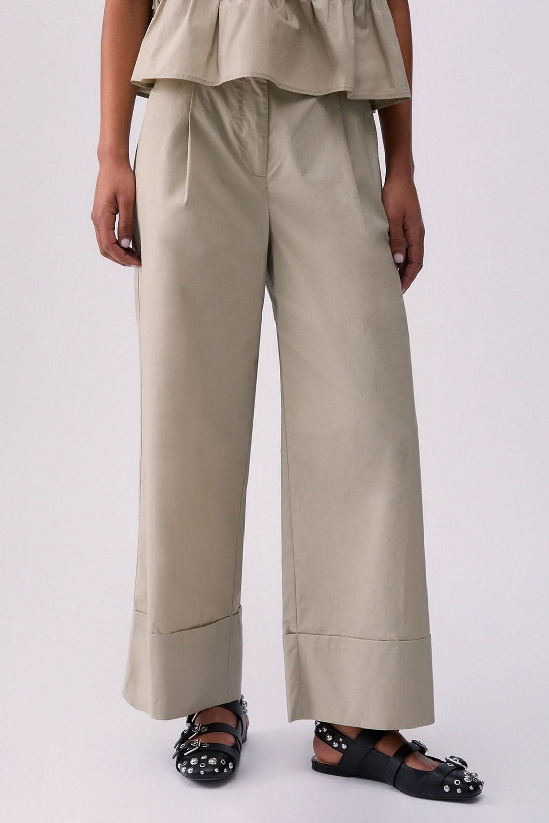 Pantalon chino à jambe large en tissu structuré avec poches latérales et finition à revers, parfait pour un look moderne et confortable.