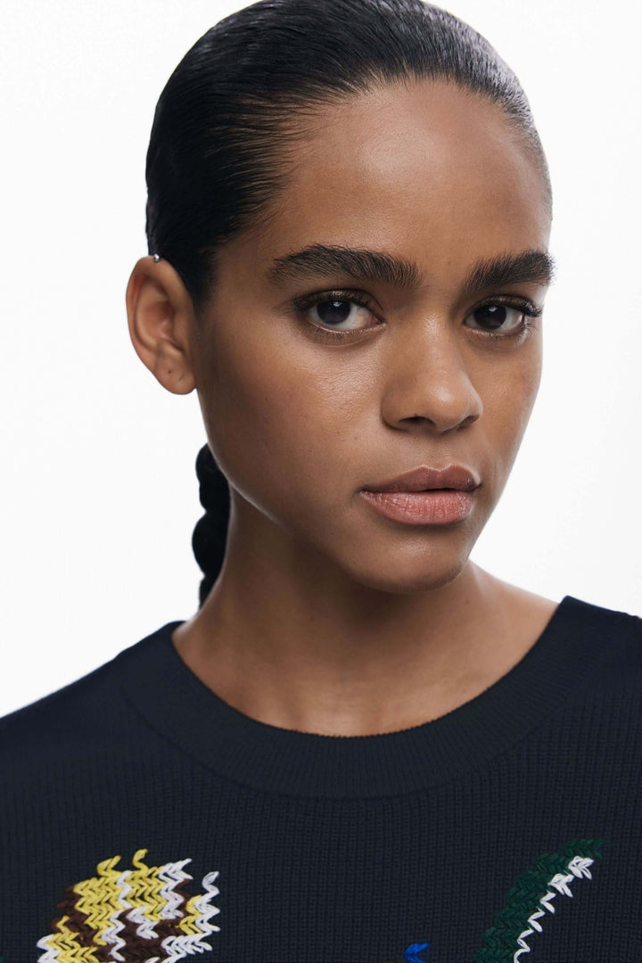 Chandail à fleurs brodées en maille texturée, coupe droite, encolure ronde, motifs floraux colorés, look artistique et moderne.