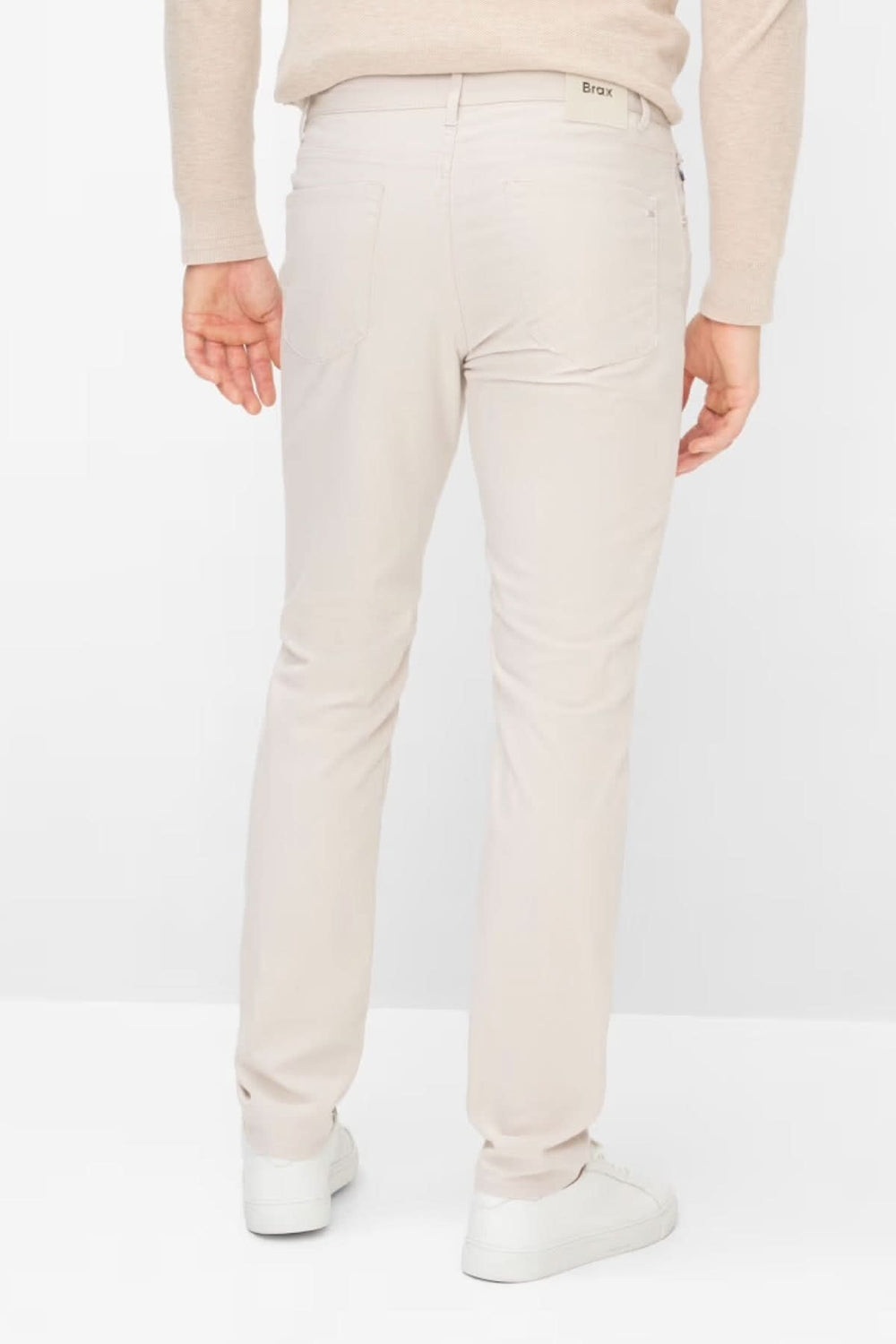 Homme portant un pantalon ajusté longueur cheville beige, parfait pour un style moderne et épuré. Décris moi le produit en français.