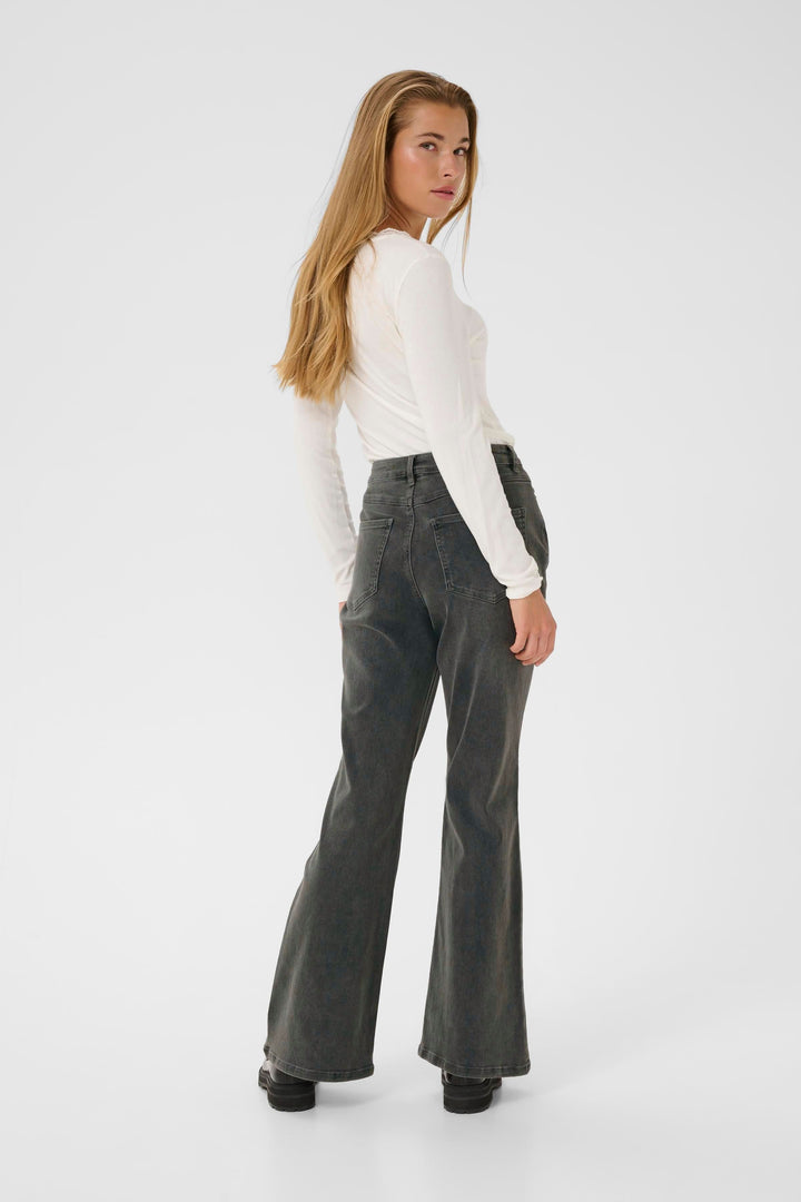 Femme portant des jeans Sinem évasés à taille haute, en finition délavée, vue de dos.