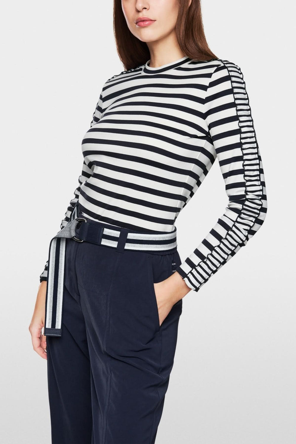 Chandail à rayures maritimes avec détails féminins et coupe ajustée, porté avec un pantalon navy.