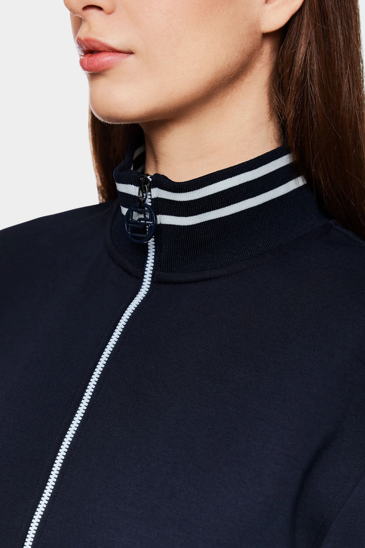 Détail d'une robe courte sportive chic avec col montant rayé et fermeture zippée, idéale pour un look moderne.