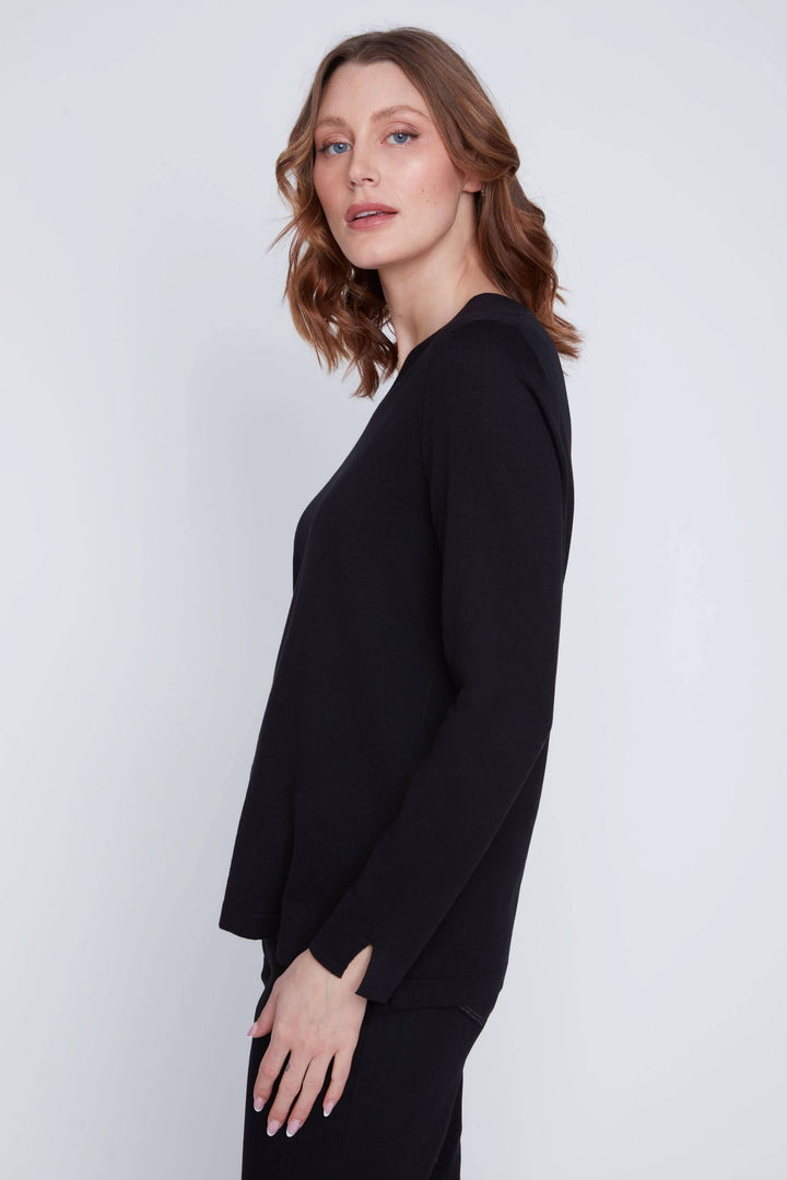 Modèle portant un chandail col V noir à manches longues avec une coupe fluide et élégante.
