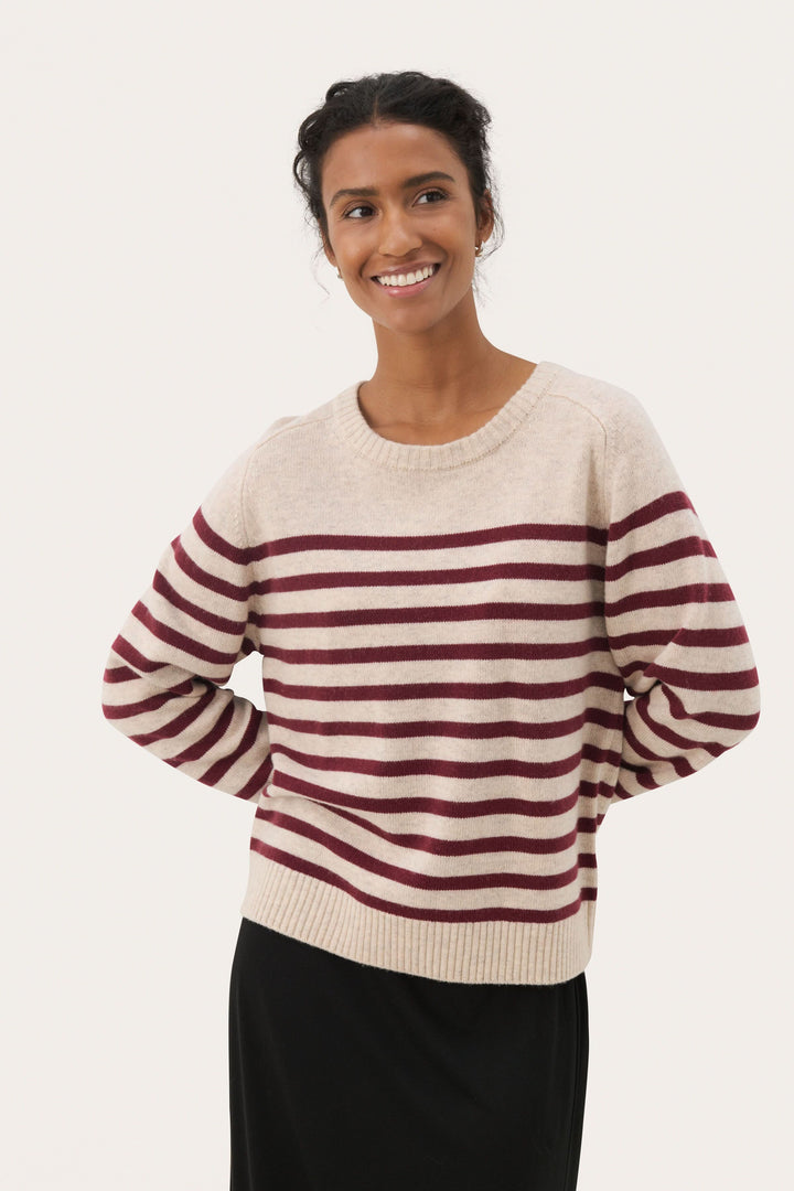 Chandail Niaka doux à rayures horizontales, encolure ronde et coupe décontractée, porté par une femme souriante.