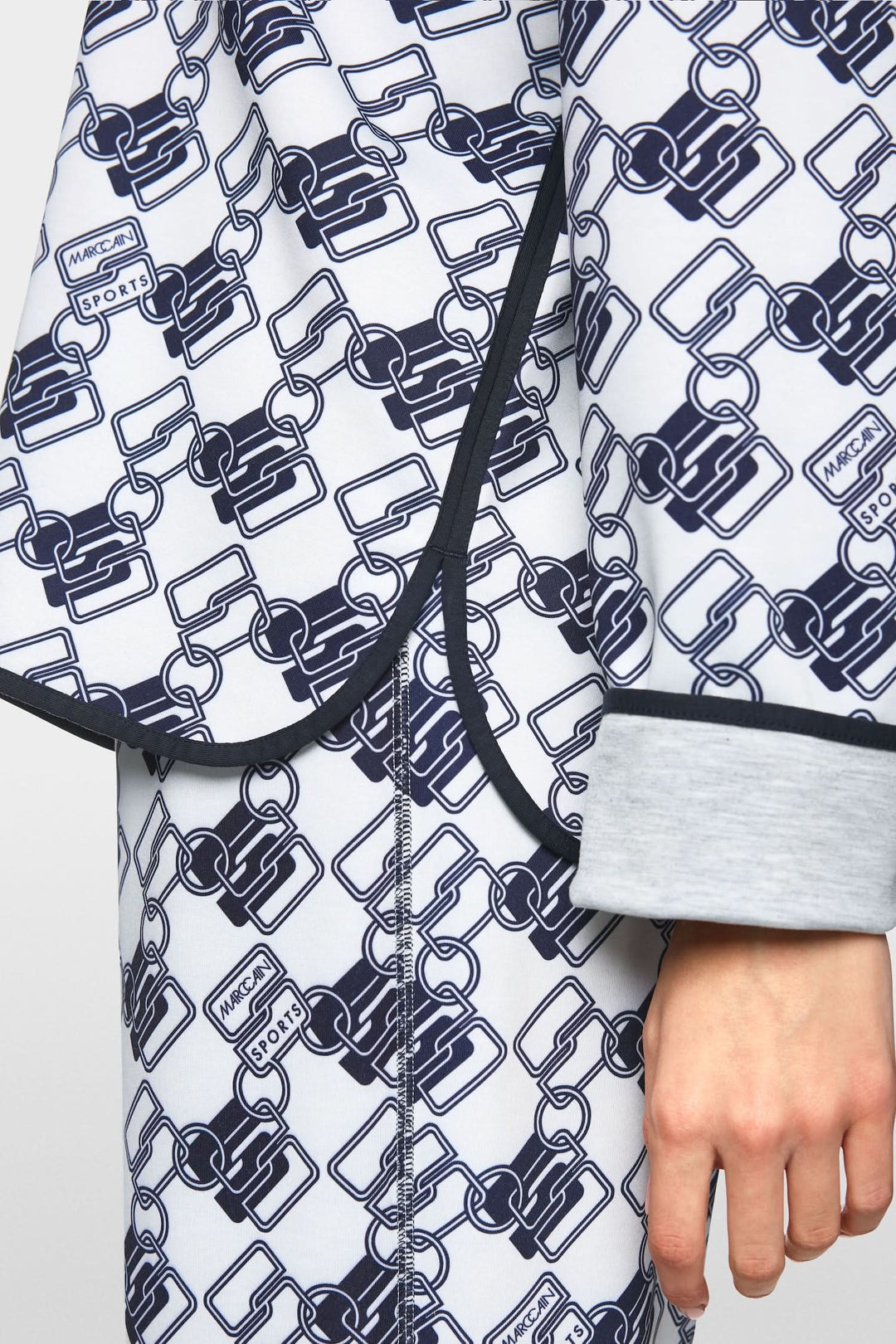 Chandail à capuche réversible avec motif géométrique moderne et détails de fente latérale.