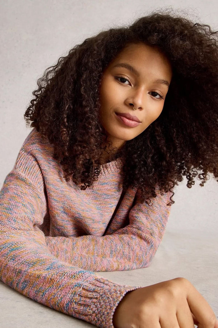 Chandail Victoria en maille légère multicolore porté par une femme avec des cheveux frisés, style moderne et décontracté.