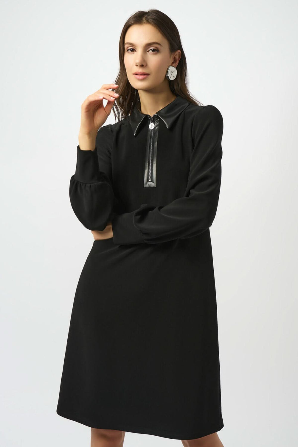 Robe trapèze noire à col chemise en similicuir, manches longues et fermeture éclair élégante.