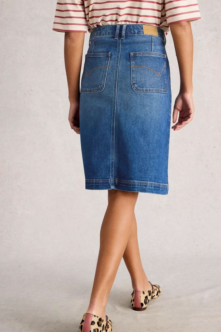 Jupe Tia en denim bleu avec coupe droite et taille haute, vue arrière, portée avec une blouse rayée.