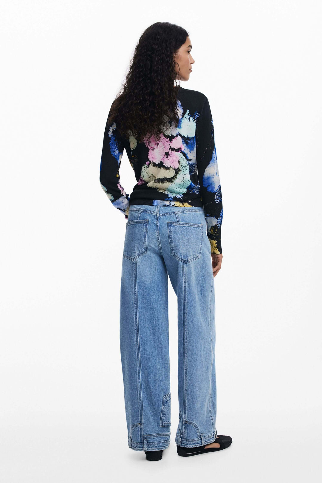 Chandail à col rond avec imprimé floral vibrant, porté avec un pantalon large en jean.