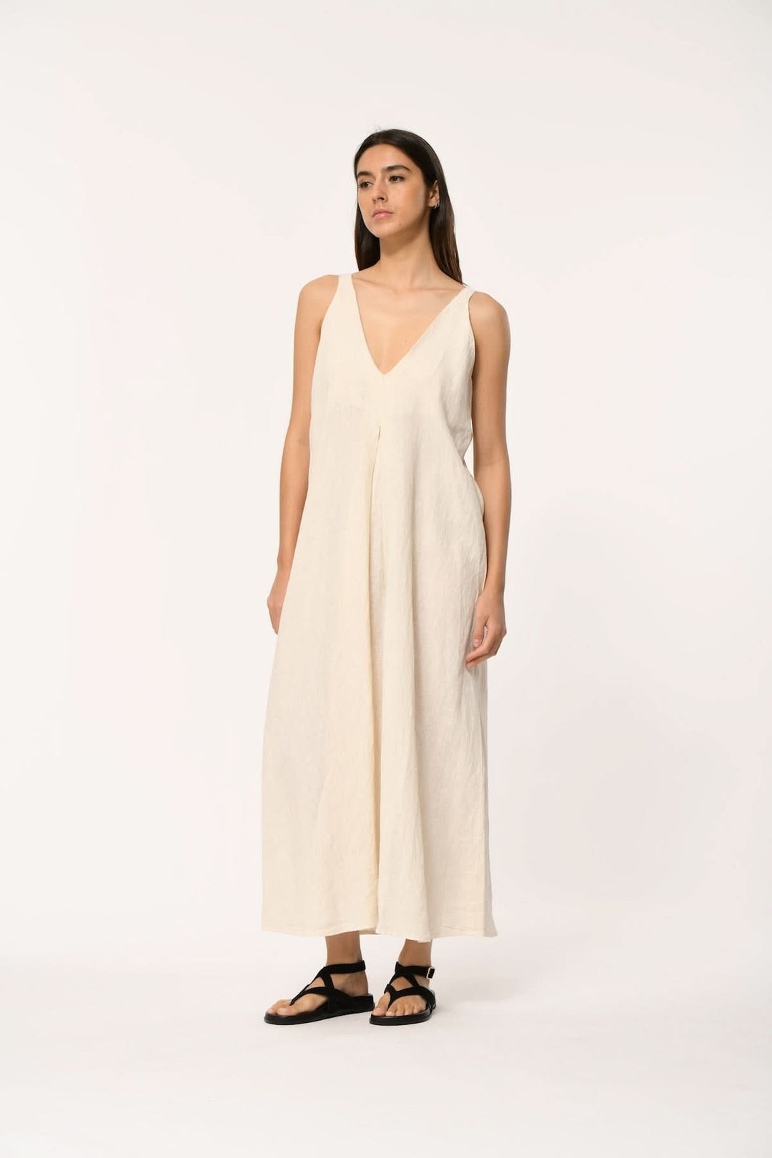 Femme portant une robe longue fluide à col v, avec silhouette épurée et coupe élégante.