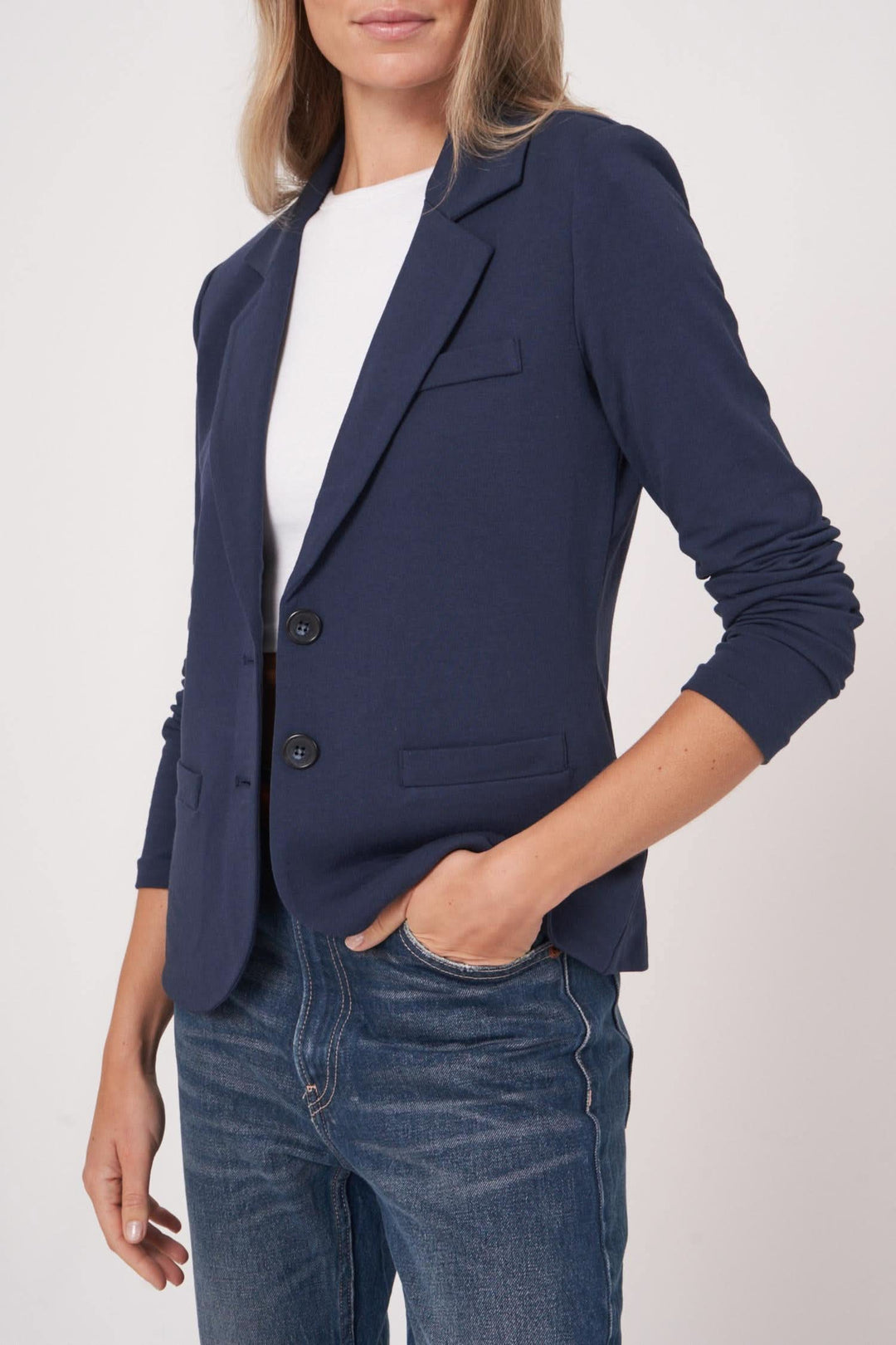 Veston en jersey stretch, coupe cintrée, coloris navy, porté avec un t-shirt et un jean.
