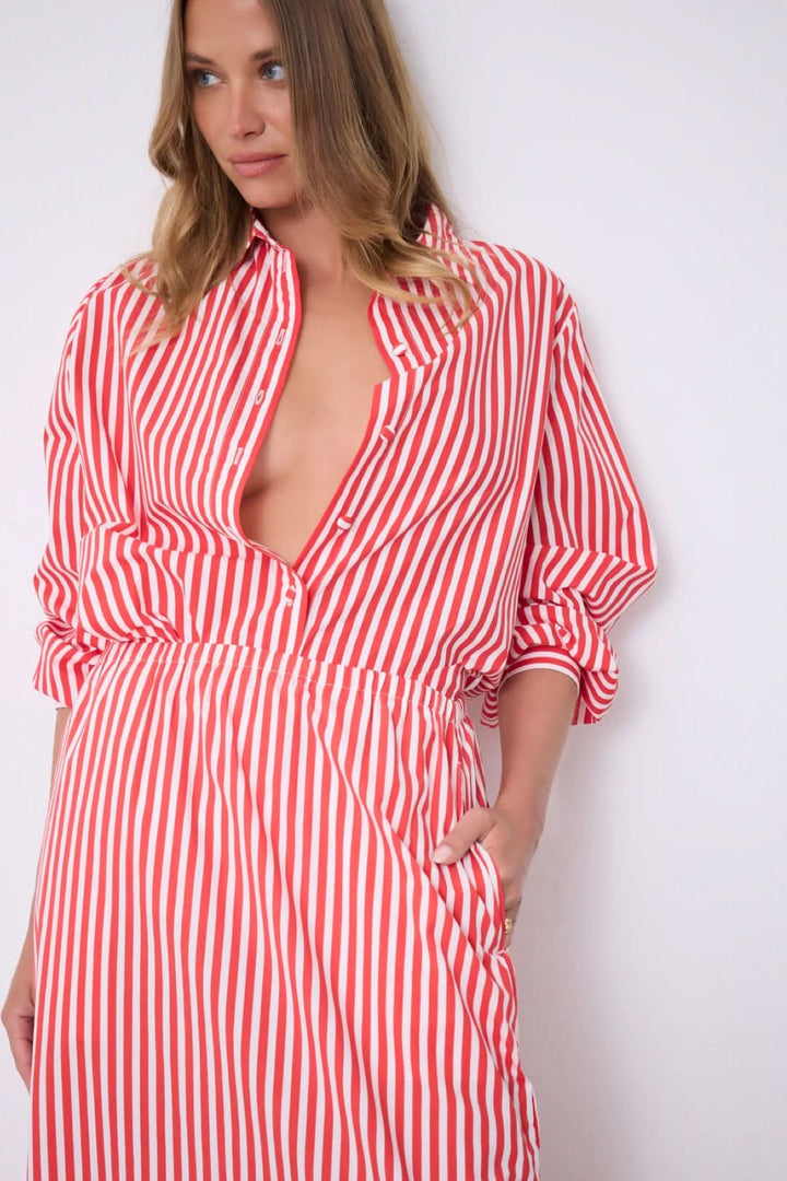 Modèle portant Jupe Ilona longue rayée taille élastique avec haut assorti, silhouette fluide et élégante, motif rayé rouge et blanc.