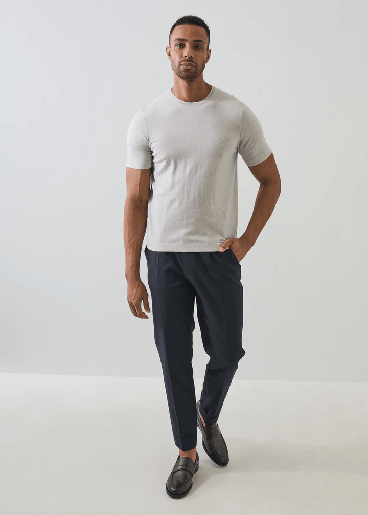 Homme portant un T-shirt en coton et cachemire blanc dans un cadre minimaliste.