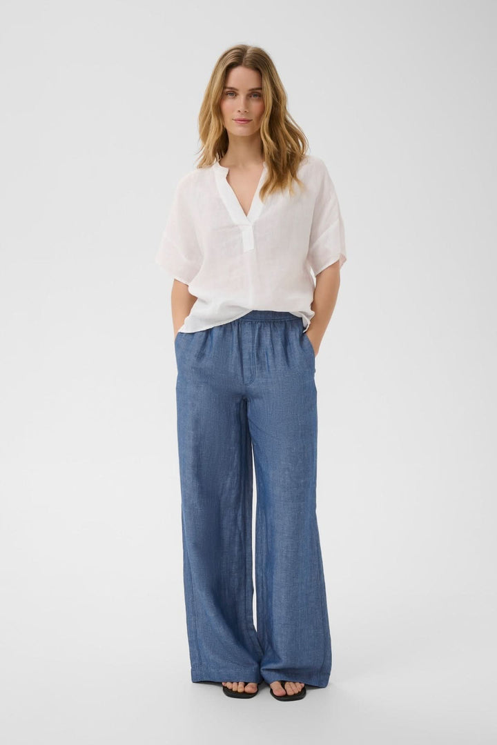 Femme portant un pantalon fluide Biana avec taille élastique et poches latérales, parfait pour un style décontracté et élégant.