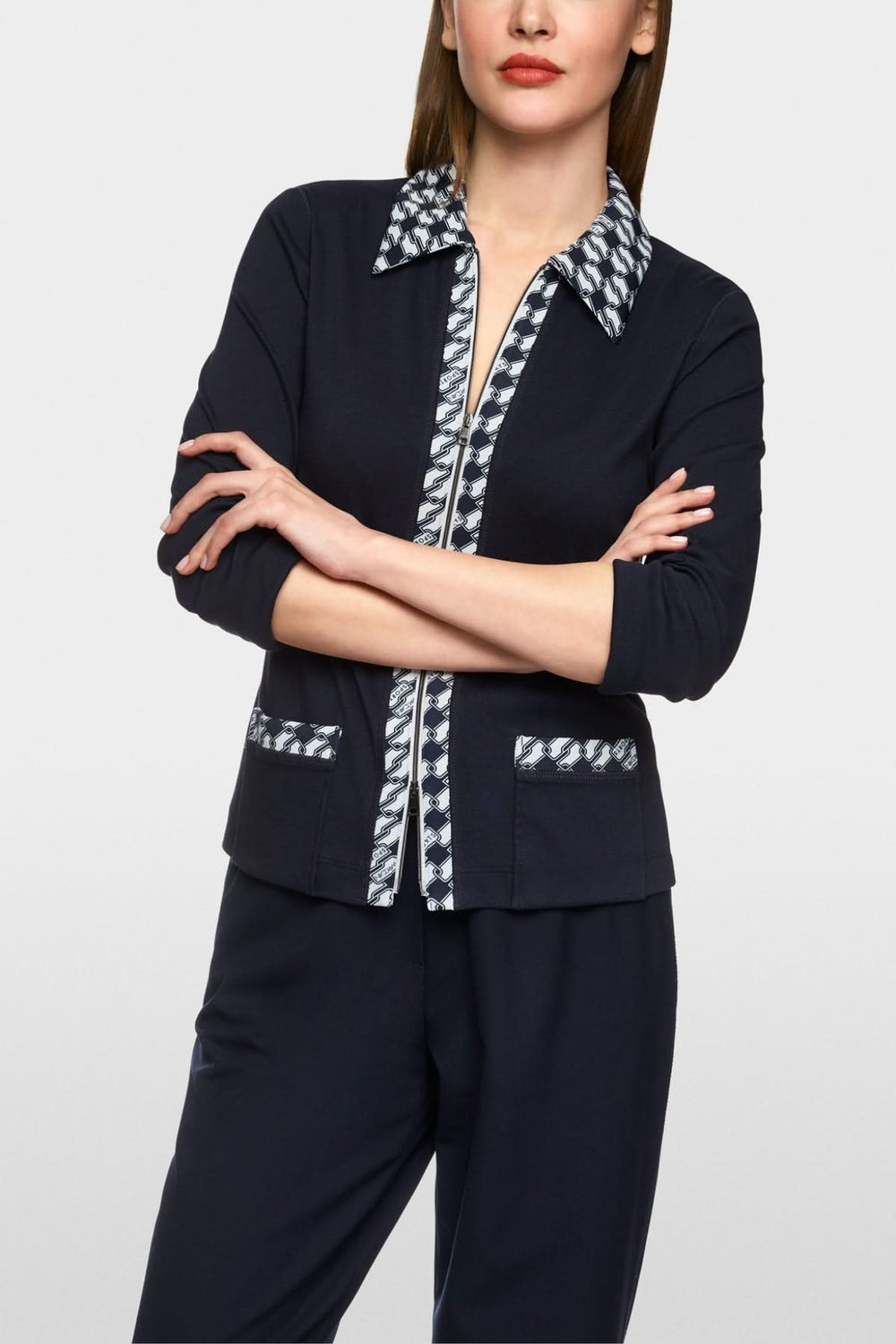 Veste en jersey cintrée avec motif graphique en cubes, col et poches plaquées, style moderne.