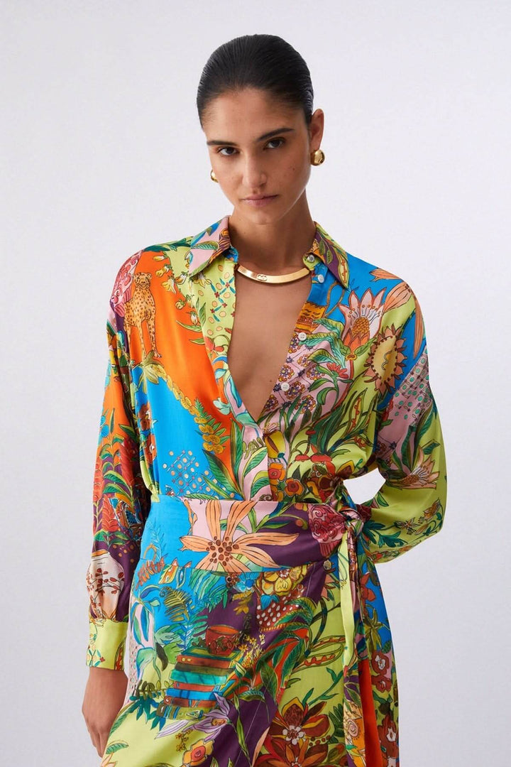 Femme portant une chemise imprimée fluide avec imprimé artistique, col classique et manches longues, offrant un style élégant et affirmé.