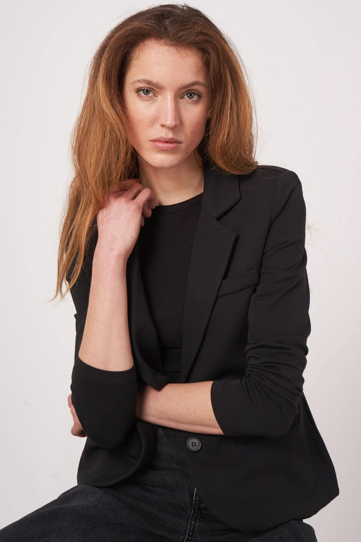 Veston en jersey stretch noir, coupe cintrée, tissu doux, idéal pour looks casual-chic et journées actives.