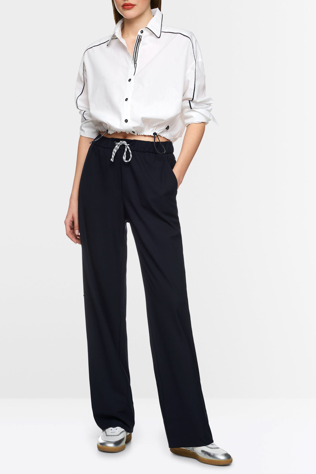 Chemise courte moderne avec cordon ajustable, portée avec un pantalon ample pour un look contemporain.