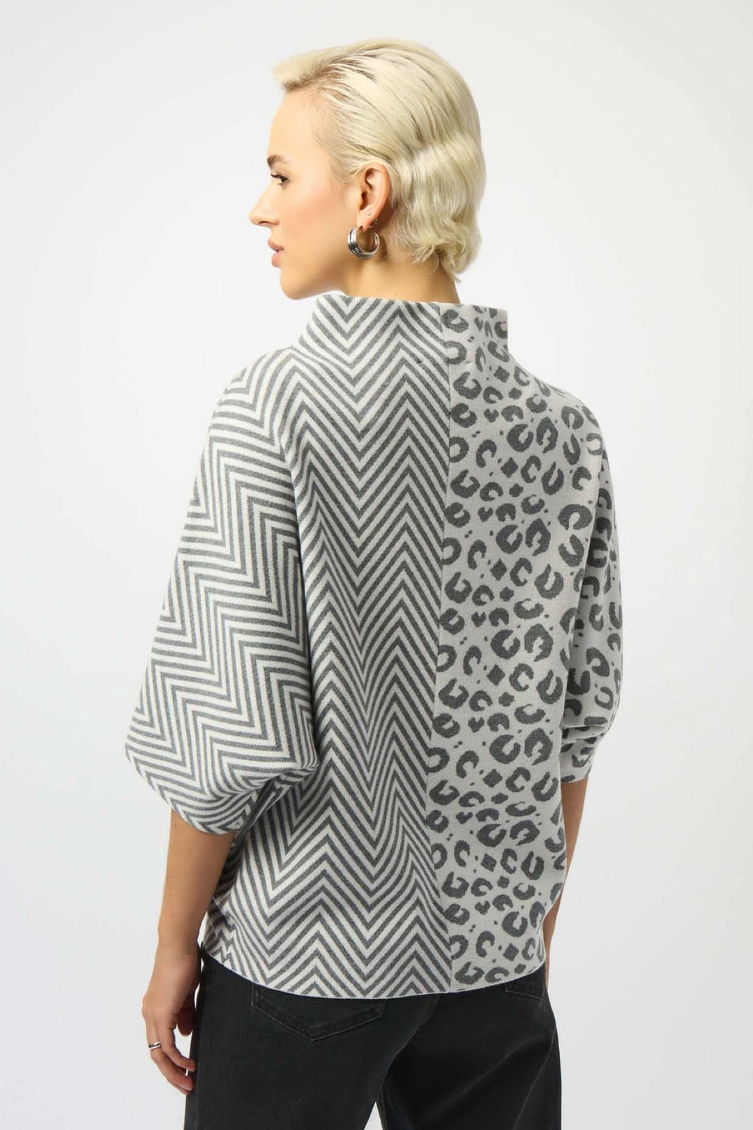 Haut à col montant à manches courtes avec motifs chevron et léopard gris sur fond blanc.
