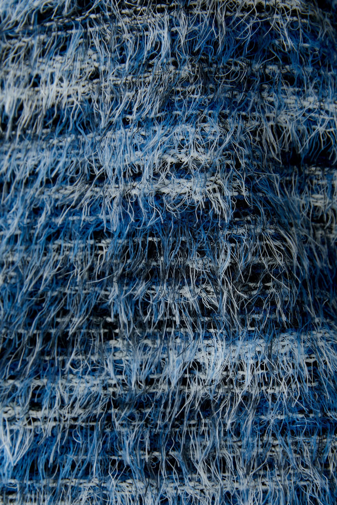 Détails moelleux en bleu d'un chandail court avec texture tricotée, montrant les fils mélangés.