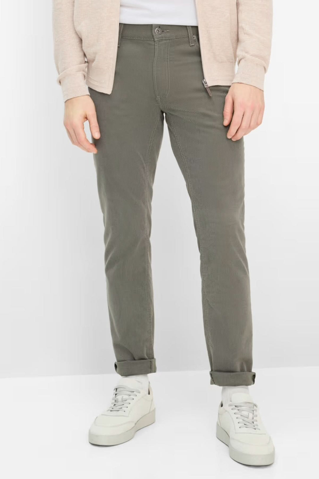 Pantalon ajusté longueur cheville en kaki, confortable et moderne, avec poches latérales, porté avec des chaussures blanches.