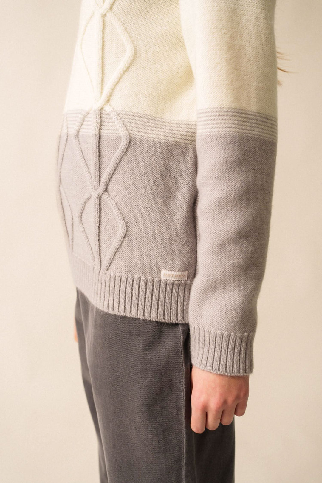 Pull en mohair structuré aux teintes beige et gris, avec col rond et logo discret.