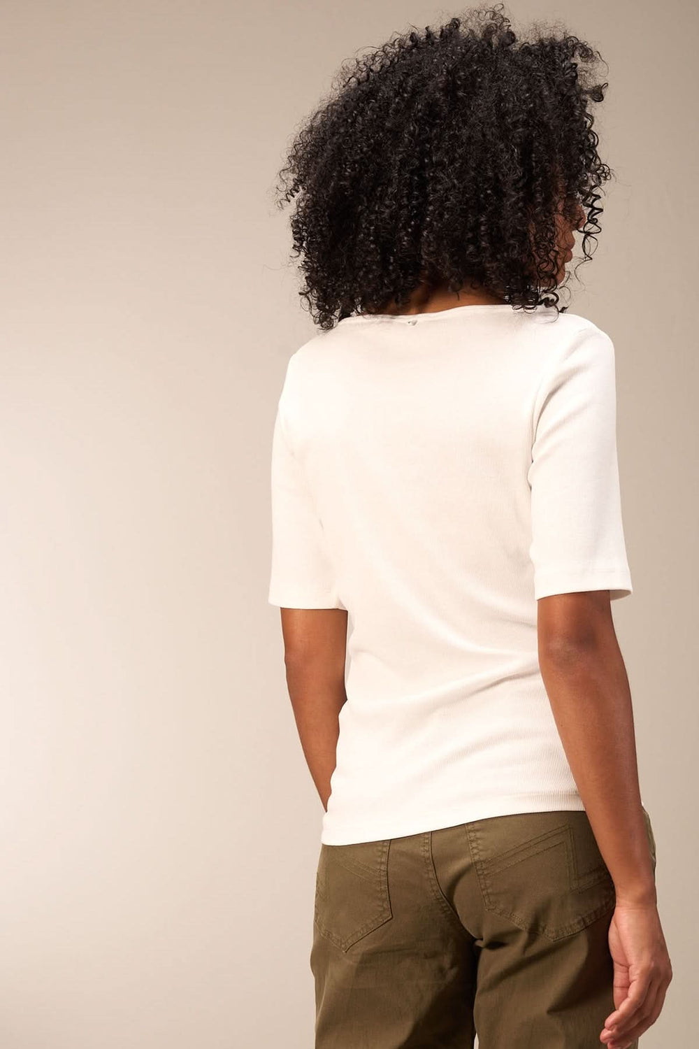 Chandail minimaliste à manches courtes, coupe ajustée, vue de dos sur modèle avec cheveux crépus.