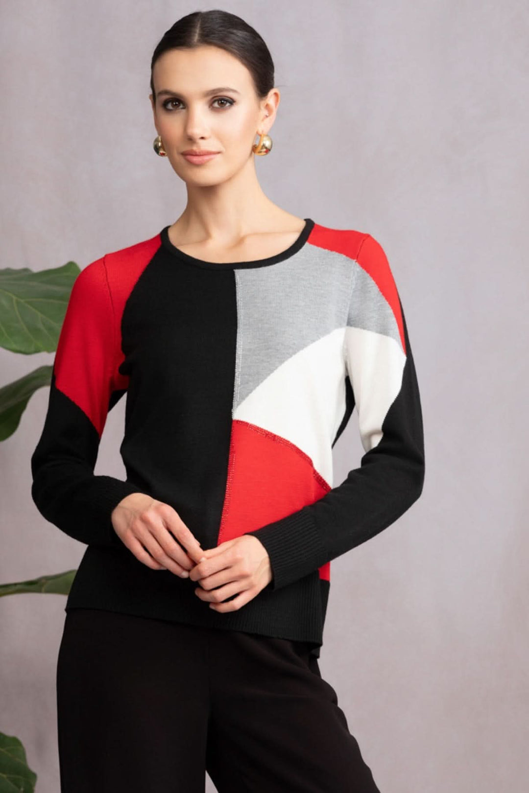 Chandail à motif géométrique en blocs de couleurs rouge, noir et gris, avec silhouette moderne et confortable.