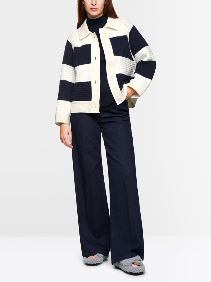 Modèle féminin portant un cardigan court à blocs de couleurs, style décontracté avec pantalon large.