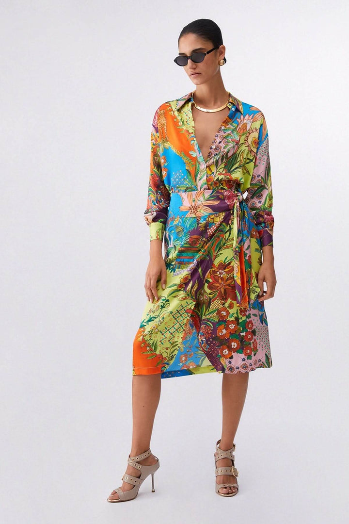 Femme portant une chemise imprimée fluide avec design artistique, col classique et manches longues, style élégant.