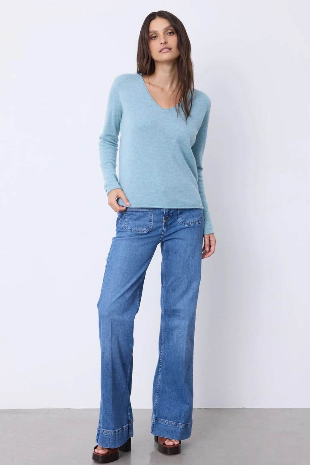 Chandail à manches longues en maille douce, encolure en V, porté avec un jean pour un look chic et décontracté.