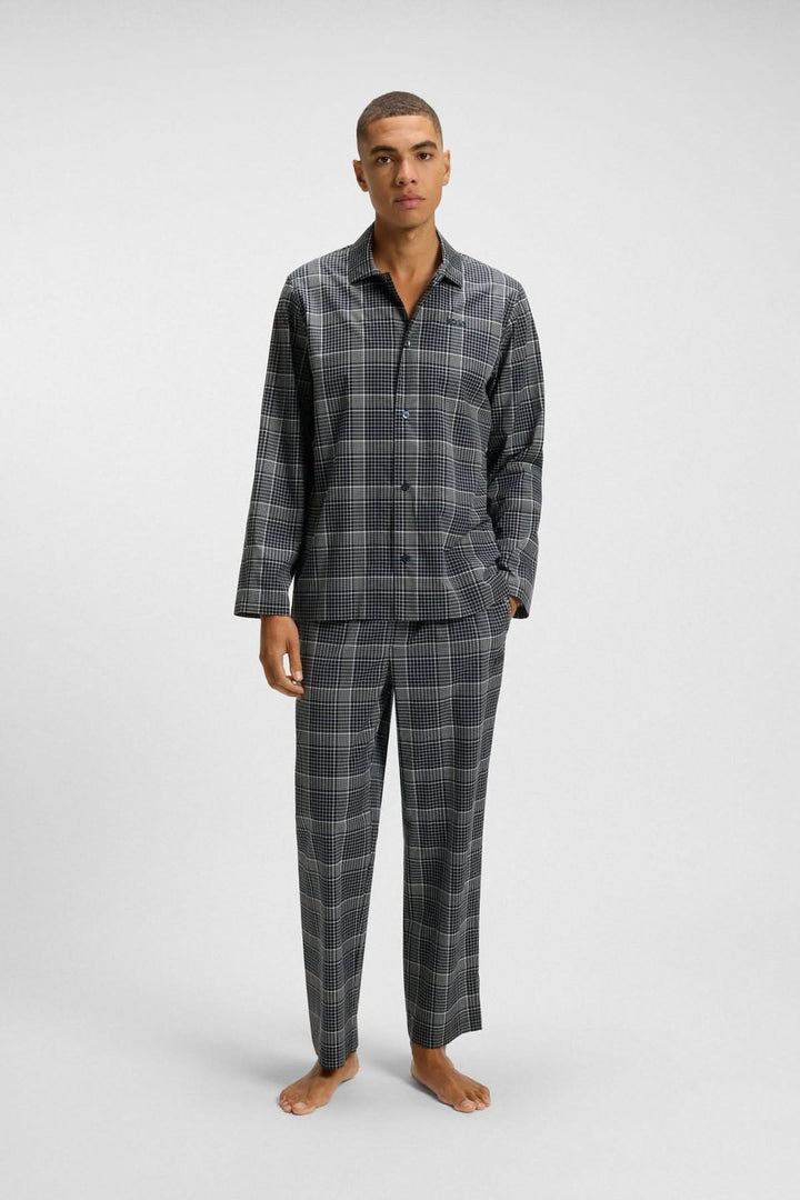 Homme portant Pyjama à carreaux en coton et lyocell BOSS, élégant et confortable, idéal pour les nuits fraîches et les soirées détente.