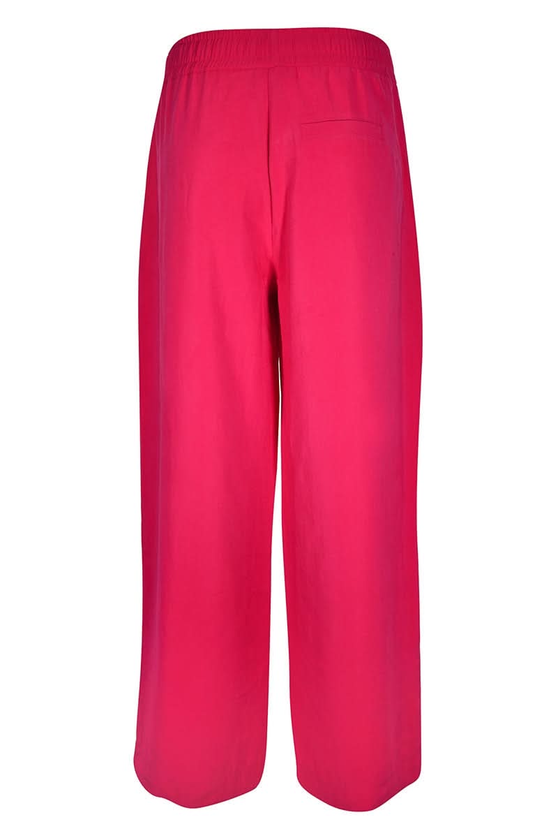 Pantalon jogging fluide rose vif avec coupe ample, taille élastique, cordon de serrage et poches pratiques. Tissu léger pour confort quotidien.