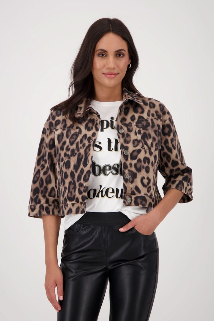 Veste courte à imprimé léopard avec manches 3/4, portée sur un t-shirt graphique et pantalon simili cuir.