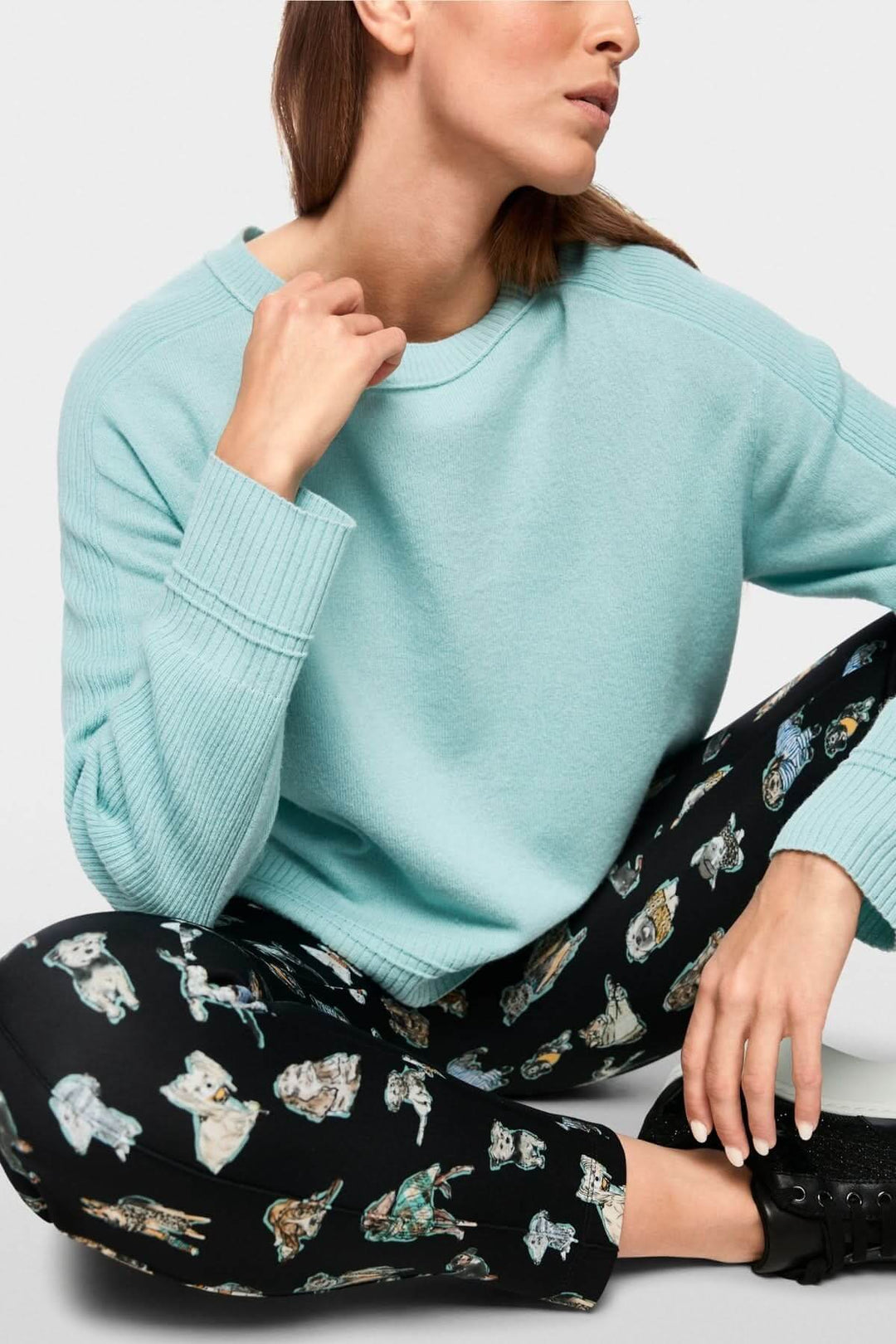 Homme portant un chandail manches longues bleu pastel avec pantalon imprimé, idéal pour un look décontracté et moderne.