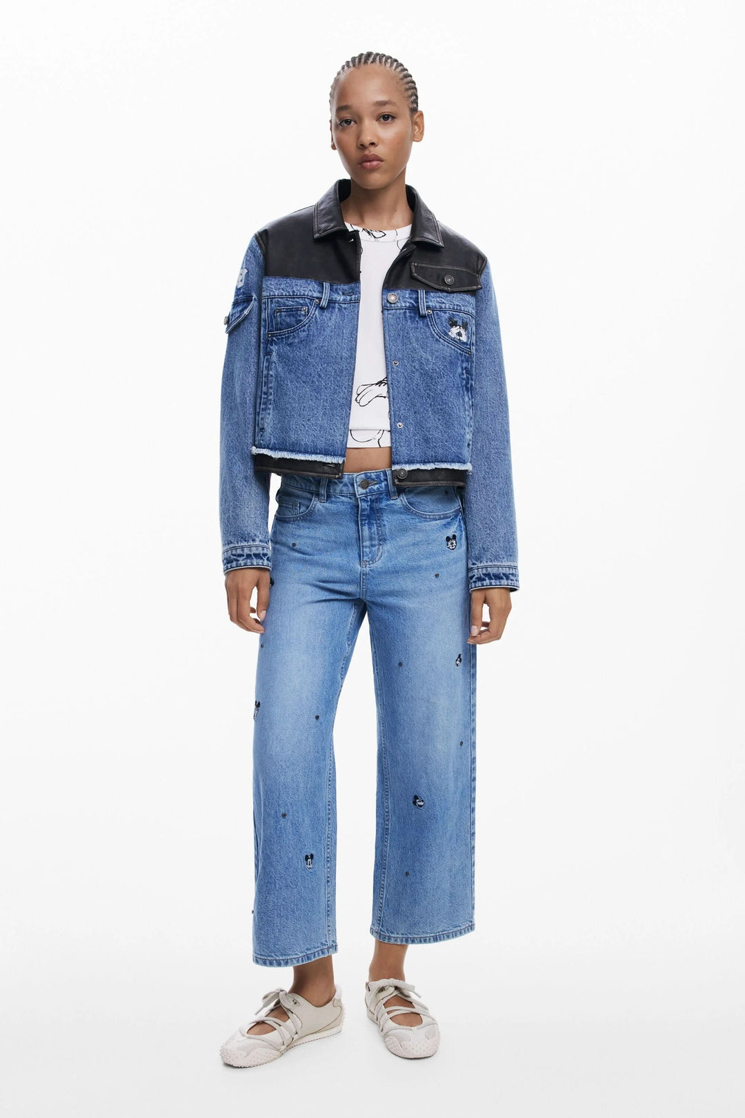 Jean à jambe large avec broderies Mickey Mouse, porté avec une veste en denim et un t-shirt graphique.