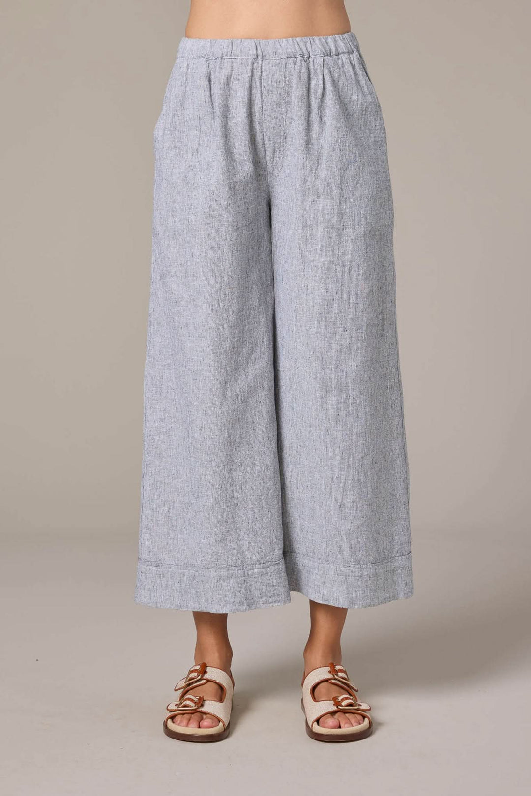 Pantalon culotte en lin à taille élastique avec poches latérales, coupe ample, jambes larges et ourlet large. Parfait pour l'été.