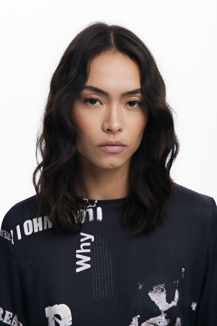 Femme portant une robe à manches longues avec un imprimé typographique audacieux, look moderne et urbain.