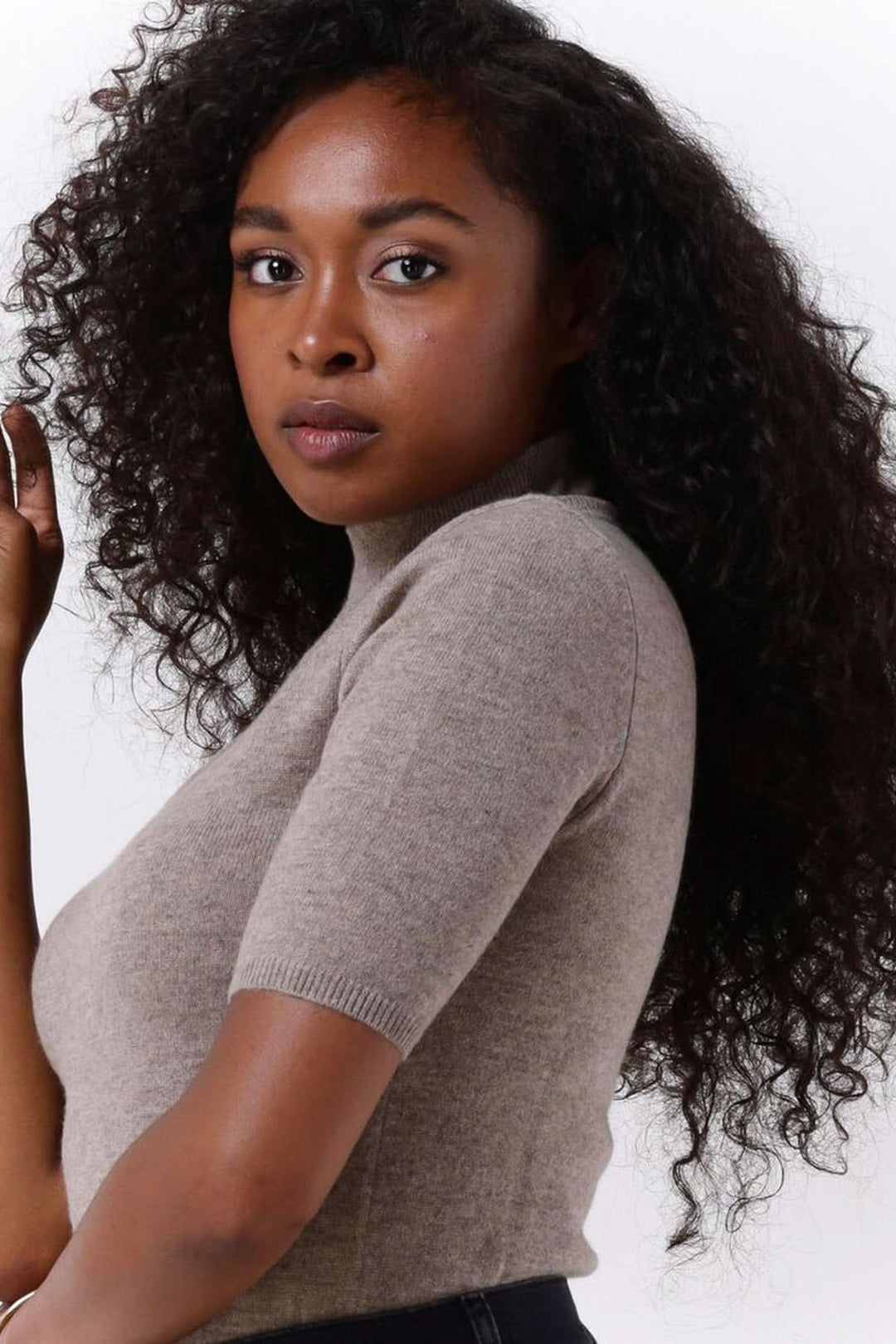 Chandail col montant manches courtes — maille fine, femme portant un chandail ajusté en maille fine avec col montant et manches courtes.