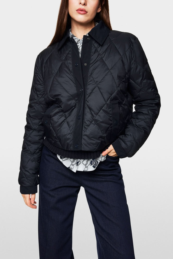 Veste matelassée noire au design écoresponsable, offrant confort et élégance, avec surpiqûres verticales.