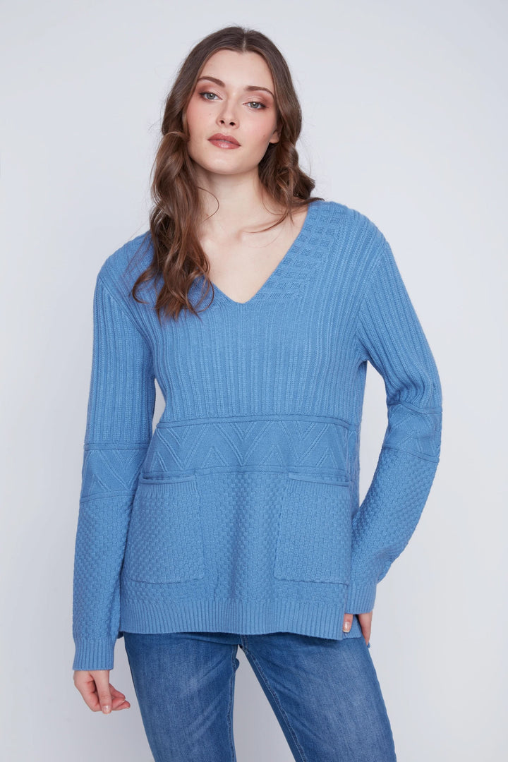 Tunique en tricot bleu à manches longues avec encolure en V et poches avant pour un style décontracté et élégant.