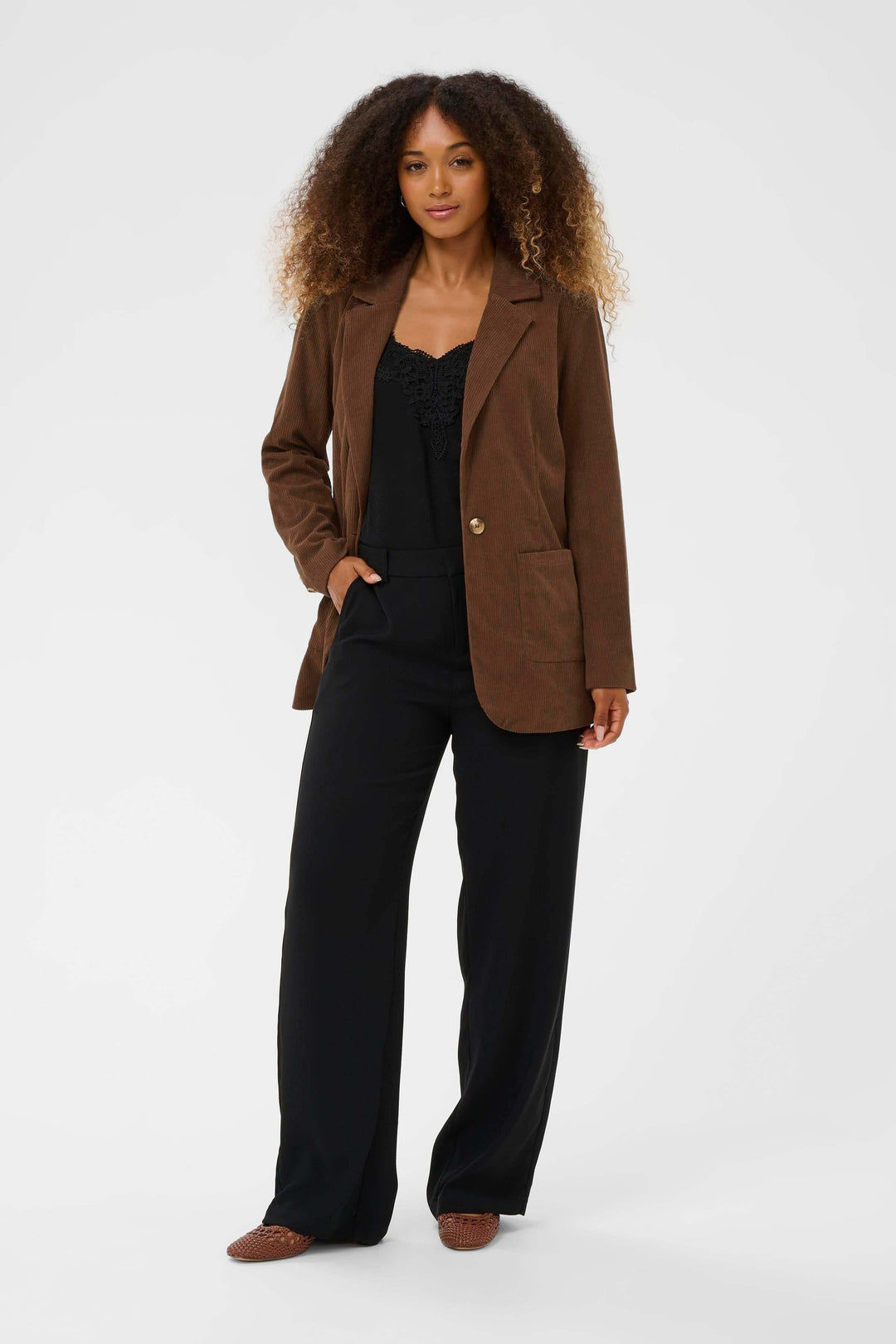 Femme portant le Veston Kanna en velours côtelé à bouton unique, style moderne et confortable, idéal pour le bureau ou le week-end.